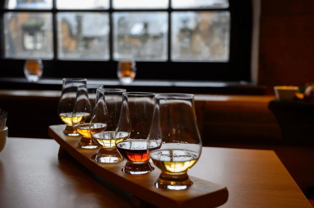 Flight of Scottish Whisky, Verkostungsgläser mit verschiedenen Single Malts oder Blended Whiskey Spirituosen auf einer Brennereibesichtigung in Schottland